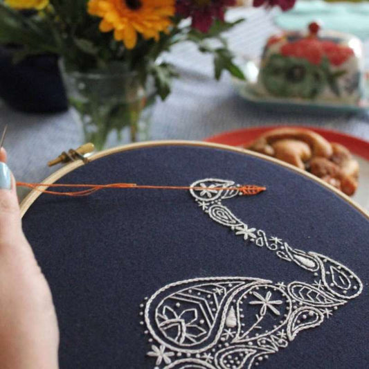 White paisley embroidered swan with orange beak close up photo